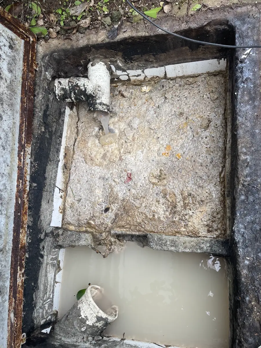 Caixa de gordura limpa após a manutenção, com a água clara e o fundo visível